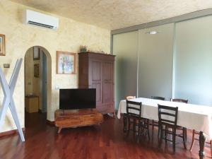 a living room with a table with chairs and a television at Lake House in Vergiate