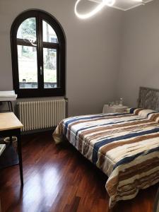 a bedroom with a bed and a large window at Lake House in Vergiate +9 photos