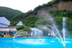 a fountain in the water in front of a building at Hotel Piccolo Paradiso - Latronico "Terme" in Latronico