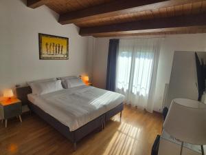 a bedroom with a bed and a large window at B&B Bella di Notte in Lugo