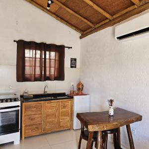 a kitchen with a wooden table and a counter top at Chalés e Suítes Campos de São João in Palmeiras