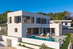 a large white house with a swimming pool at Lemon Tree Villa in Splitska