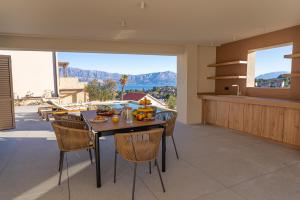 a dining room with a table and chairs with a view at Lemon Tree Villa in Splitska