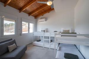 a living room with a couch and a desk at Villa Consta with Tennis, Saltwater Pool & Sea Views by KB Hospitality in Dhaskalión