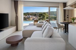 a living room with a couch and a tv and a table at Lemon Tree Villa in Splitska