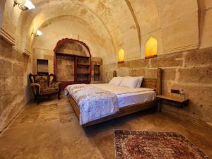 a bedroom with a bed in a stone room at Key of Cappadocia - House of Beautiful Horses in Avanos