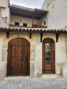 two wooden doors on the side of a building at Key of Cappadocia - House of Beautiful Horses in Avanos