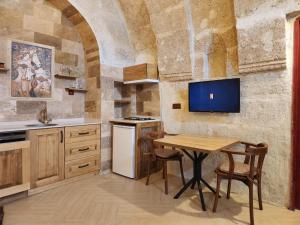 a kitchen with a table and a tv on the wall at Key of Cappadocia - House of Beautiful Horses in Avanos