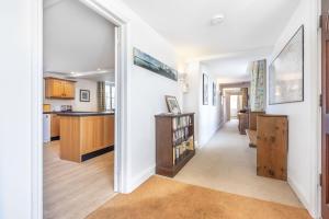 a hallway leading to a kitchen with white walls at Nelson Lodge in Burnham Market
