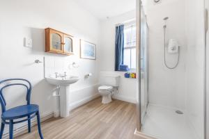 a bathroom with a toilet and a sink and a shower at Nelson Lodge in Burnham Market