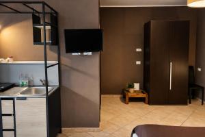 a kitchen with a sink and a tv on the wall at MyBed B&B in Cavallino di Lecce +10 photos