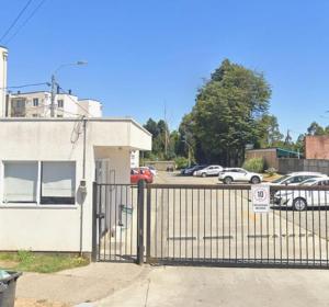 a gate in front of a parking lot with cars at departamento Eli in Valdivia