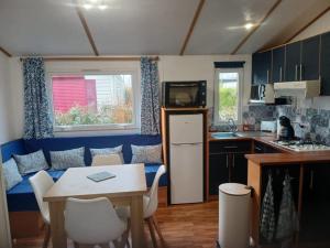 a kitchen with a table and a kitchen with a couch at Escapade aux Peupliers in Vironchaux