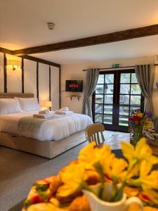 a bedroom with a bed and a table with yellow flowers at Lake Cottages at Cwm Chwefru in Llanafan-fawr