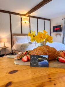 a table with a loaf of bread and a vase with flowers at Lake Cottages at Cwm Chwefru in Llanafan-fawr