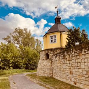 a stone wall with a tower on top of a building at Pension EdHeLo in Barby