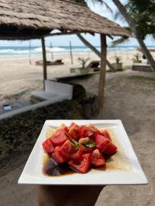 a plate of food sitting on a table near the beach at O'Sole Mio Assinie - La résidence in Assinie