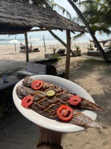 a plate of food with tomatoes on the beach at O'Sole Mio Assinie - La résidence in Assinie +21 photos