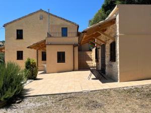 a house with a large patio in front of it at Vineyard Farmhouse in Massignano in Massignano