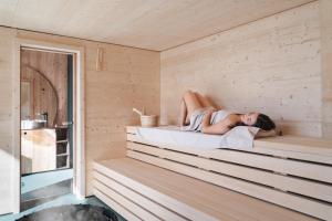 a woman laying in a sauna at Agritur Lawanda in Vezzano +75 photos