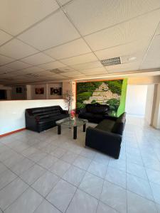 a living room with two black couches and a table at Hotel Boutique Los Laureles in Tuxtla Gutiérrez