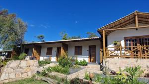 a house with a stone wall at Chalés e Suítes Campos de São João in Palmeiras