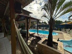a resort with a swimming pool and a palm tree at Pousada Barumar in Lucena +18 photos