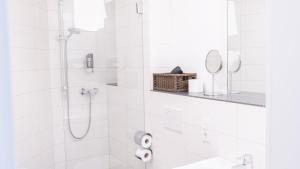 a white bathroom with a shower and a sink at Alembra - Wein Style Hotel in Trier