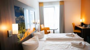 a hotel room with two beds and a window at Alembra - Wein Style Hotel in Trier
