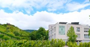 a white building with a clock on the side of it at Alembra - Wein Style Hotel in Trier