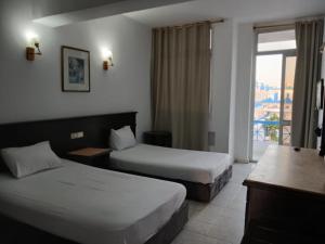 a hotel room with two beds and a window at Regency Hotel Sharm in Sharm El Sheikh