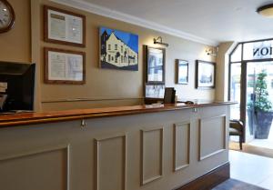 a bar in a restaurant with a clock on the wall at Ye Olde Talbot Hotel by Greene King Inns in Worcester