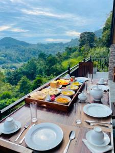 a table with plates of food on top of a balcony at Paddy Breeze Cabana Ella in Ella