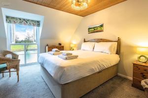 a bedroom with a large bed and a window at Isis Lakes 79, Reflections - P in South Cerney