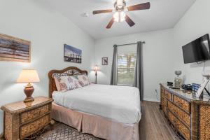 a bedroom with a bed and a ceiling fan at The Dunes 101 by Vacation Homes Collection in Fort Morgan +39 photos