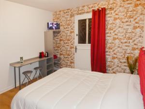 a bedroom with a white bed and a red curtain at Les Bergeronnettes in Trénal