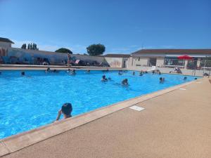 a group of people swimming in a swimming pool at Mobilhome spacieux in Pornic