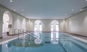 a swimming pool with a staircase in a building at Au Petit Chateau les Bains a Thermen Morvan in Saint-Honoré-les-Bains