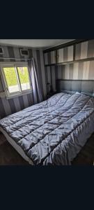 a large bed in a room with a window at Mobilhome spacieux in Pornic