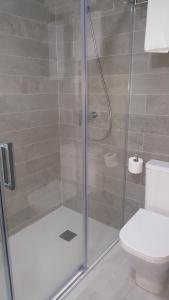 a bathroom with a glass shower with a toilet at Sol Playa Suites in Valencia +25 photos