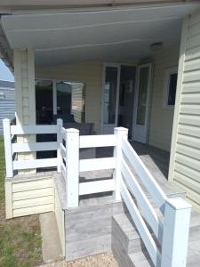 a white fence on the front porch of a house at Mobilhome spacieux in Pornic