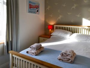 a bedroom with a bed with towels on it at Gullsway in Beadnell +4 photos