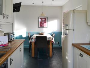 a kitchen with a table and a refrigerator at Gullsway in Beadnell