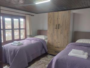 a bedroom with two beds and a wooden cabinet at Minihome Konak in Safranbolu