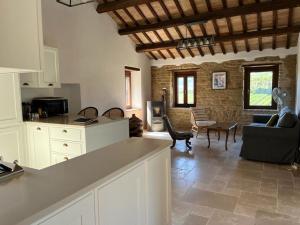 a kitchen and living room with a couch and a table at Vineyard Farmhouse in Massignano in Massignano