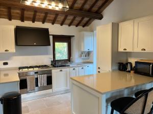 a kitchen with white cabinets and a stove top oven at Vineyard Farmhouse in Massignano in Massignano +65 photos