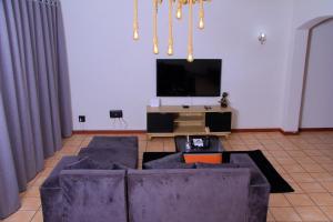 a living room with a couch and a flat screen tv at Wakanda in Johannesburg