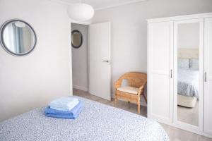 a bedroom with a bed and a mirror and a chair at San Lorenzo House in Gijón