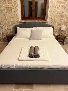 a bed with two socks and two pillows on it at Vineyard Farmhouse in Massignano in Massignano