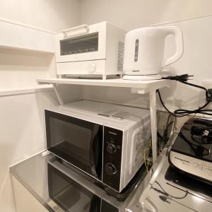 a microwave on a shelf with a blender on top of it at AJITO Hostel 別館2 in Shingū +2 photos